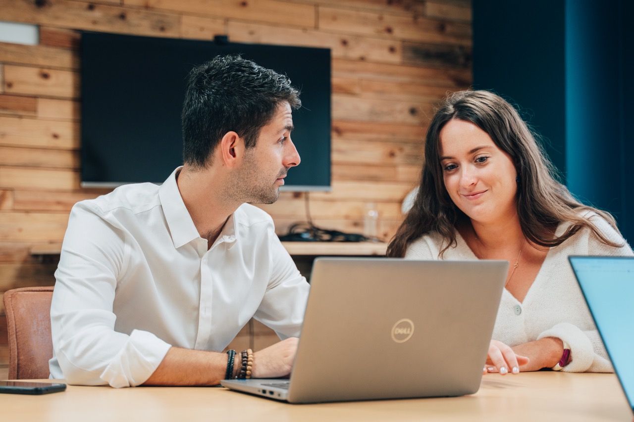 Une femme et un homme travaillent sur un ordinateur. 