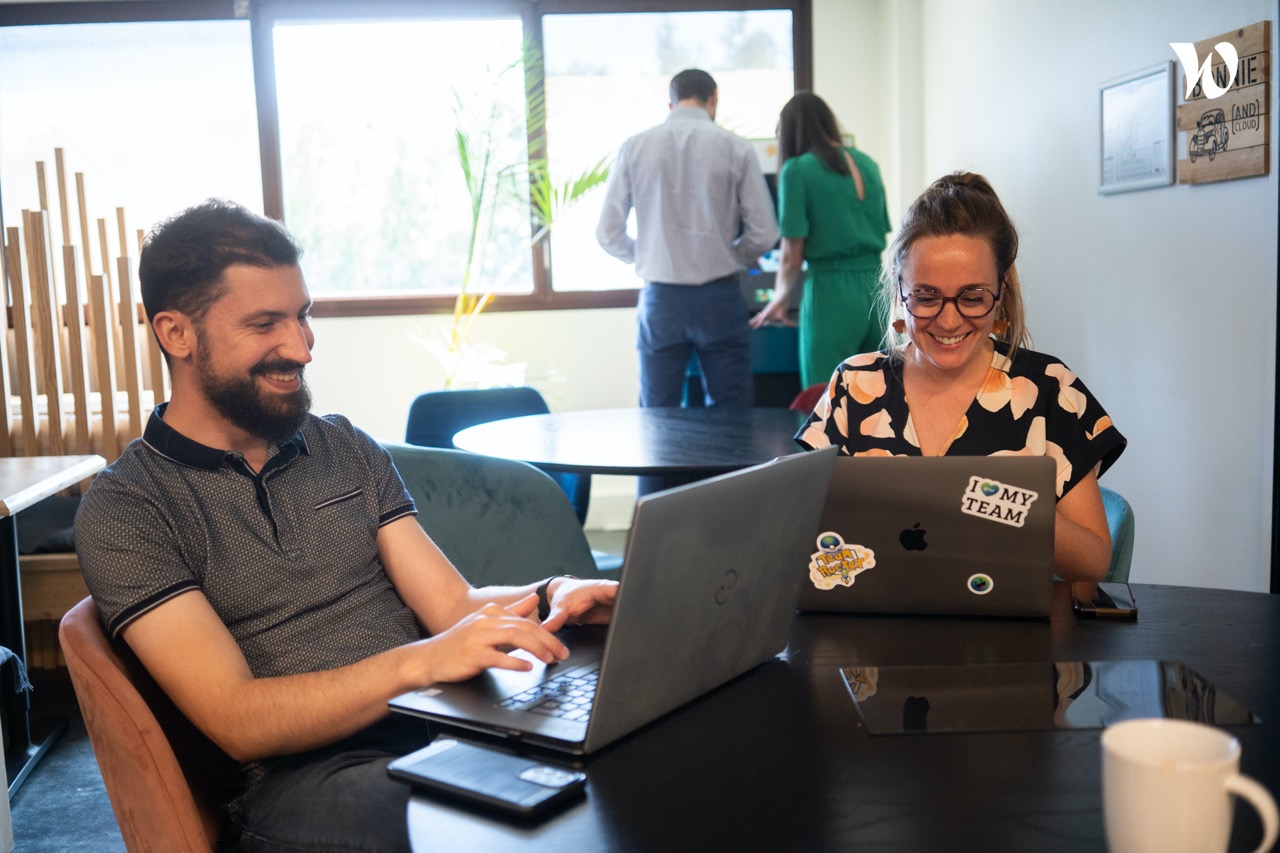 Une femme et un homme travaillent sur leurs ordinateurs. 